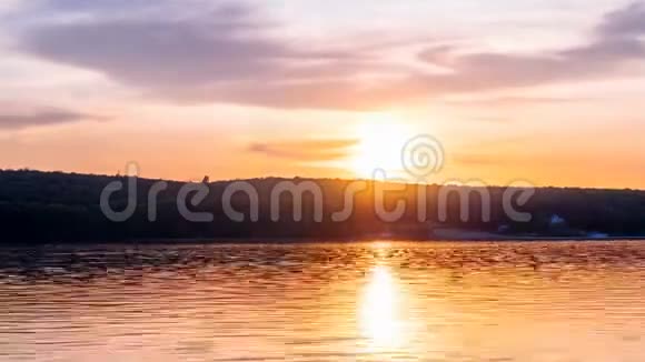 光线在夜空中伸展着云彩湖面日落的天空时间流逝太阳盘在前面躲在浓密的条纹后面视频的预览图