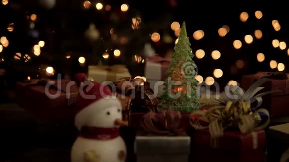 圣诞礼品盒雪人和圣诞树灯光闪烁背景明亮视频的预览图