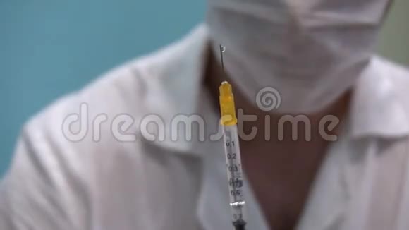 带口罩的医生手里拿着注射器准备射击视频的预览图
