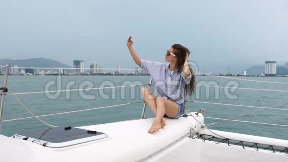在船上度假时拍摄自画像照片的女人视频的预览图