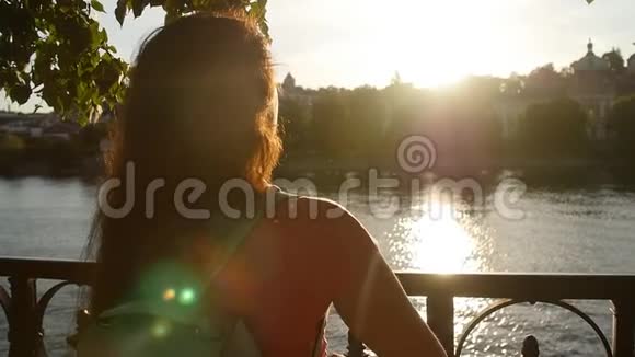 年轻女子在夕阳下做壁炉的象征视频的预览图