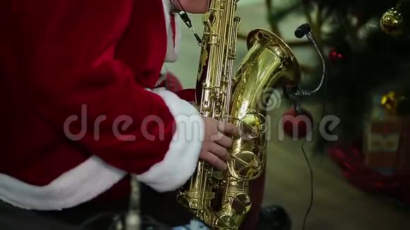 身穿圣诞礼服的男子在节日音乐会上演奏萨克斯管圣诞颂歌视频的预览图