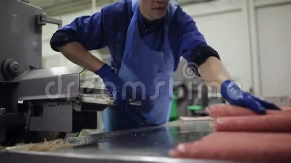 熏香肠的生产和包装过程这名工人管理一台自动机器用于生产视频的预览图