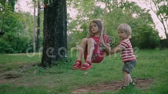 孩子们兄妹在公园里两个小孩坐在公园里视频的预览图