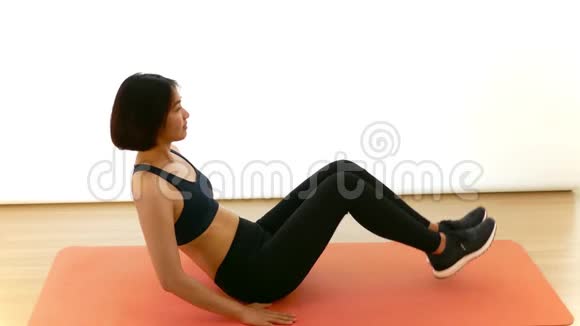 在白色背景的健身节目中漂亮的泰国女孩正在做腿部按压或V紧缩仰卧起坐锻炼视频的预览图