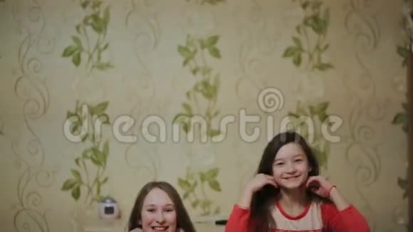十几岁的女孩跳着扔头发在公寓里享受假期视频的预览图