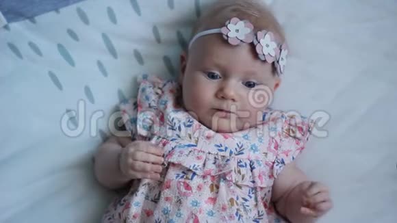 三个月大的蓝眼睛小女孩一个新出生的孩子一个可爱平和体贴的小女孩看着惊讶的微笑视频的预览图