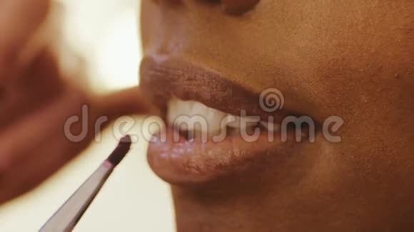 美容店化妆师用化妆刷在女人脸上涂唇视频的预览图