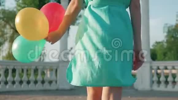 美丽的女孩红色的头发和五颜六色的气球旋转和笑白色的背景美丽的少年视频的预览图