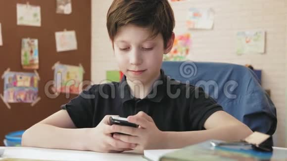 可爱的小男孩在社交网络上用智能手机发短信视频的预览图