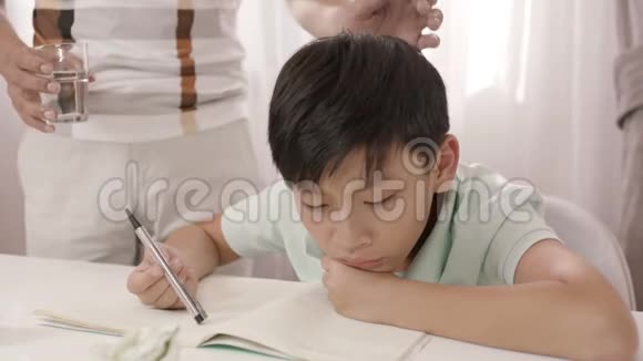 亚洲的父亲站着听着沮丧的儿子模糊的家庭作业视频的预览图