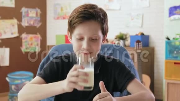 可爱的小男孩喝了一杯牛奶竖起大拇指视频的预览图