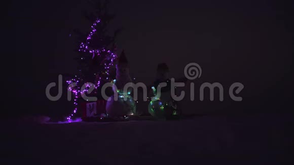 带圣诞礼物的雪人两个雪人站在冬天的圣诞节风景视频的预览图