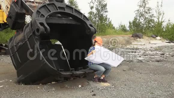 女工程师检查一个坐在挖掘机大桶里的计划视频的预览图