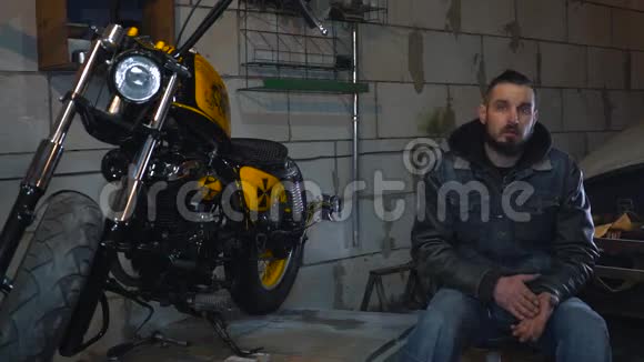 机械师坐在车库里谈论制造摩托车的细节视频的预览图