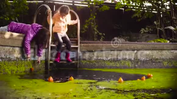 两个女孩在长满浮萍的老游泳池附近玩耍视频的预览图