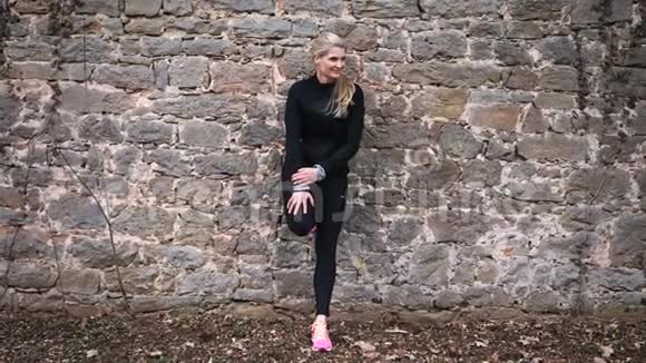 女慢跑者在古老的砖墙边休息视频的预览图