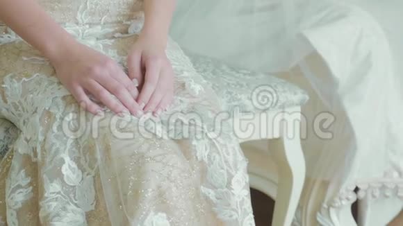 年轻新娘穿着婚纱的作物体坐着化妆师作为作品视频的预览图