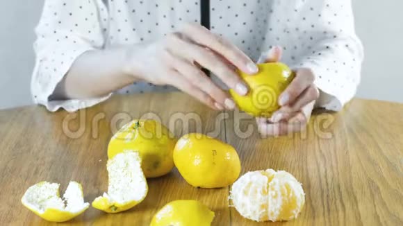 女人用手剥一只橘子把手举起来视频的预览图