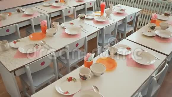 幼儿园的餐桌上有盘子杯子叉子和勺子准备午休表格设置视频的预览图