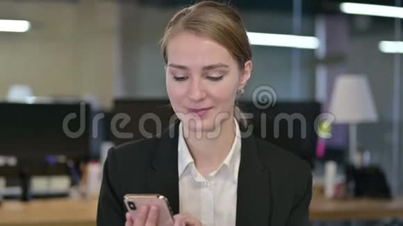 年轻商务女性在智能手机上聊天的肖像视频的预览图