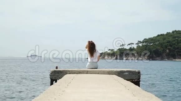 女人坐在岛湾码头视频的预览图