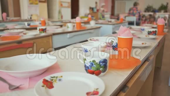 幼儿园的餐桌上有盘子杯子叉子和勺子准备午休表格设置视频的预览图