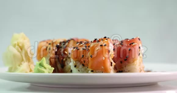在白色盘子上吃寿司的人围绕着它的轴线侧视视频的预览图
