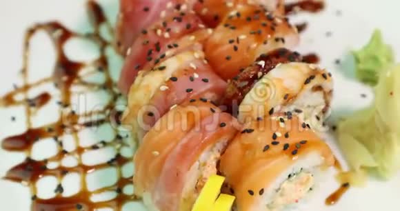 在白色盘子上吃寿司的人围绕着它的轴线俯视视频的预览图