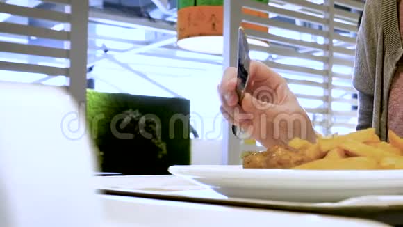 餐馆里的女人吃薯条肉丸子视频的预览图