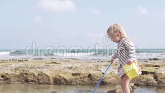 美丽的小女孩在海边的海滩上玩耍视频的预览图