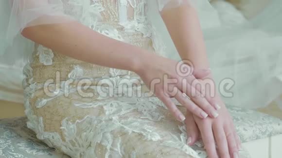 年轻新娘穿着婚纱的作物体坐着化妆师作为作品视频的预览图
