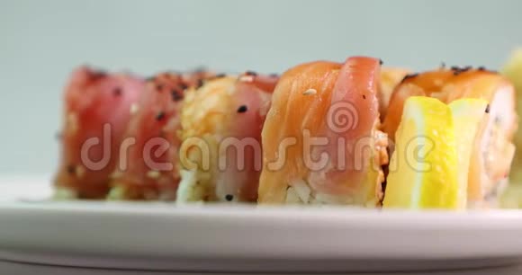 在白色盘子上吃寿司的人围绕着它的轴线侧视视频的预览图