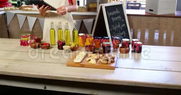 女职员在柜台上摆放橄榄蜜饯和橄榄油视频的预览图