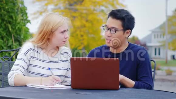 两个商人亚洲男人和高加索女人交流用笔记本电脑工作视频的预览图