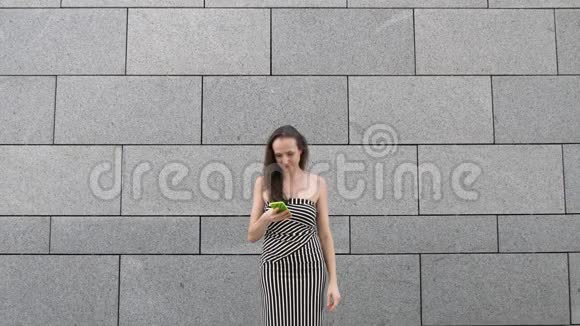 优雅美丽的女人惊讶于短信信息快乐的舞蹈和跳跃在城市灰色的城市背景视频的预览图