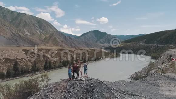 空中的背着背包的旅行者微笑着在镜头前挥手一家人在山上靠近视频的预览图