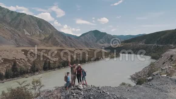 空中的背着背包的旅行者微笑着在镜头前挥手一家人在山上靠近视频的预览图