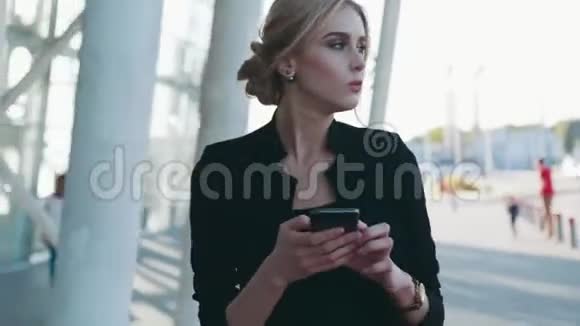 时尚发型的漂亮女商人匆匆经过机场候机楼在手机上发短信视频的预览图