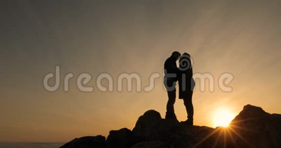 幸福的情侣在一起亲吻和享受日落的剪影带着希望展望未来视频的预览图
