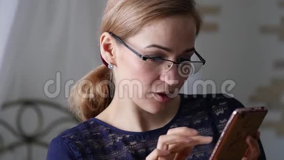 戴眼镜的金发女商人在智能手机上检查一些东西慢动作视频的预览图