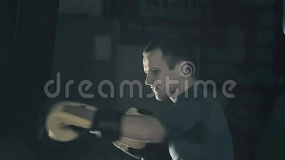 运动员在比赛前训练一个拳击手打了那个沉重的袋子黑色背景视频的预览图