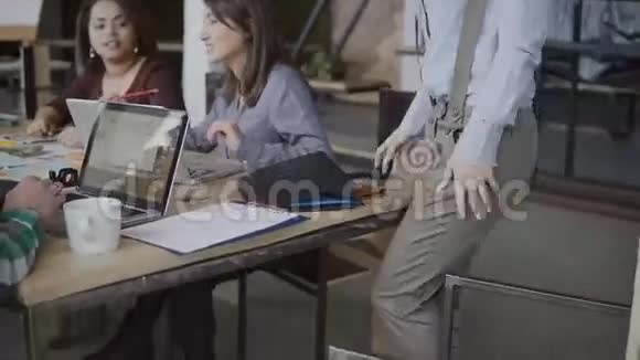 女经理来到团队坐在桌边和男同事握手现代办公室的创意商业团队视频的预览图