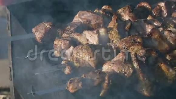 在阳光明媚的日子里在户外烤架上烤串上特写美味的肉片多汁烤肉视频的预览图