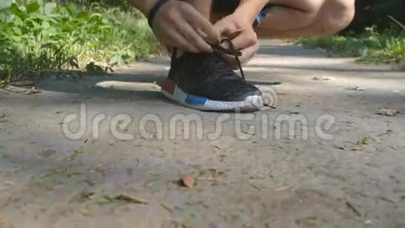 在公园里系鞋的活跃的健康人士运动员在乡村路线锻炼训练中慢跑前系鞋带视频的预览图