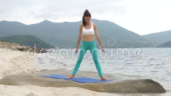 年轻健康运动的女人在海上做深蹲运动视频的预览图