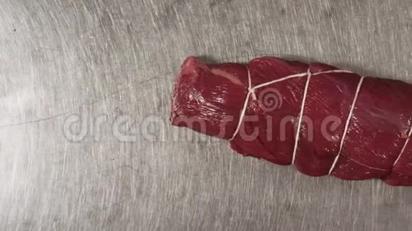 一块新鲜的红肉的特写镜头场景用食物绳绑住的一块肉的俯视图视频的预览图