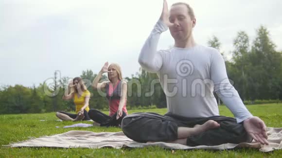 公园瑜伽教练教两个有魅力的女孩视频的预览图