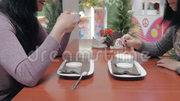 两个女孩在咖啡馆里喝咖啡和聊天视频的预览图