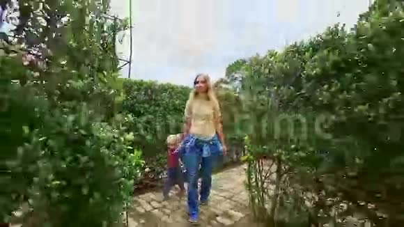 母亲小女孩行走在公园的长边迷宫之间视频的预览图